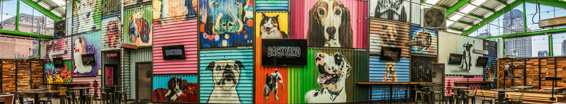 mural painted with images of dogs and cats with led screens over it